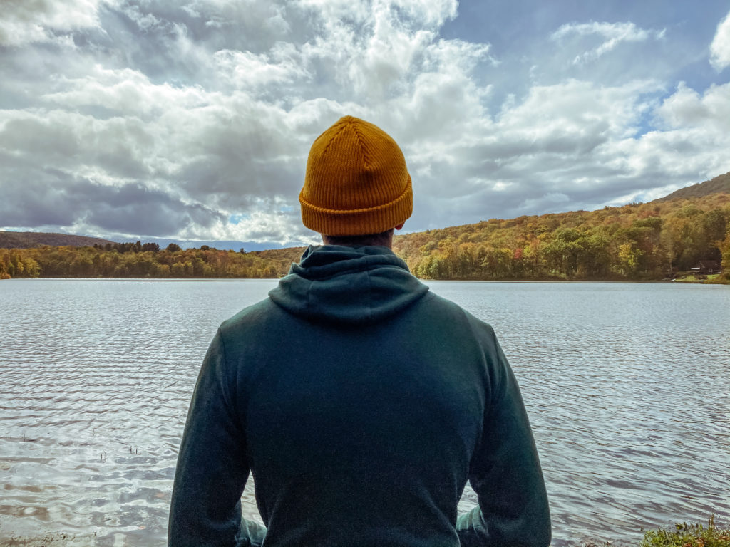 a man staring out over a cold lake