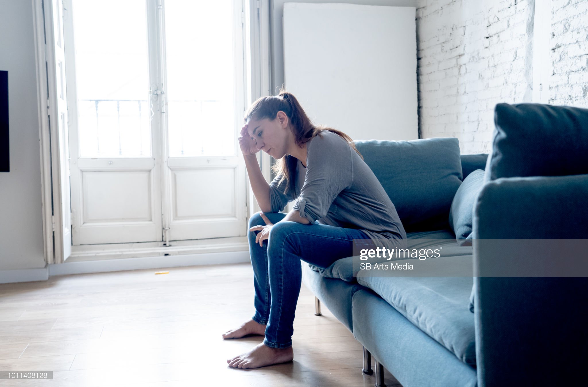 Young attractive latin woman lying at home living room couch feeling sad tired and worried suffering depression in mental health, problems and broken heart concept.